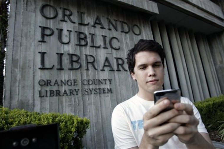 Hillard Goodspeed uses an ipod application called  \"shake it\",  to find reading suggestions at the Orlando Public Library in Orlando, Fla., Wednesday, Sept. 1, 2010.(AP Photo/John Raoux)